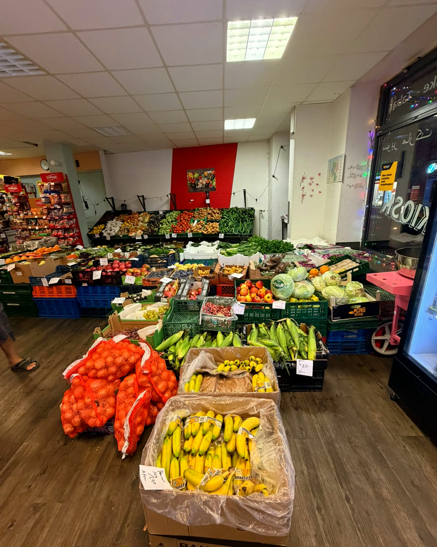 Der große Obst- und Gemüsestand mit Bananen, Zwiebeln, Mais und Äpfeln