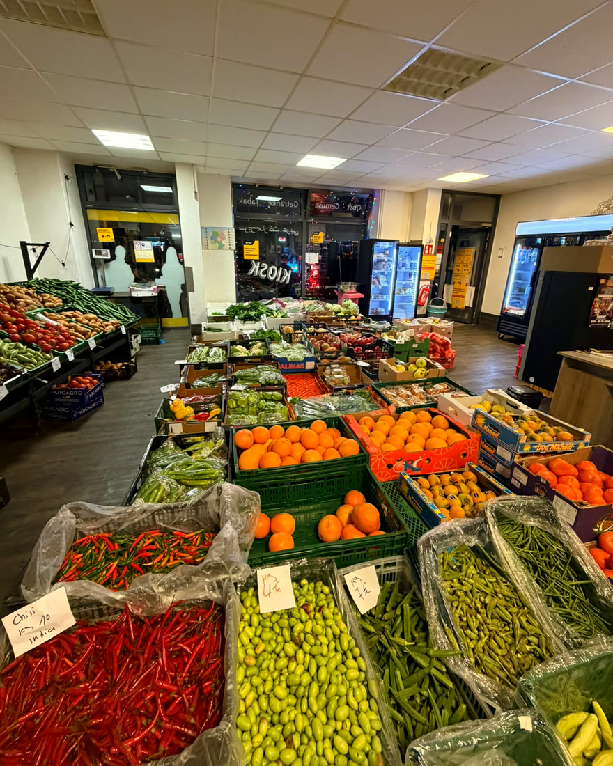 Kisten mit roten Chilis, Okra, Bohnen und Orangen